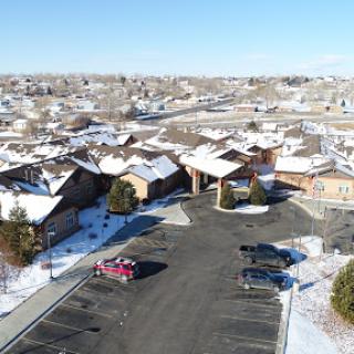 A serene aerial view of a snowy suburban neighborhood with a parking lot.