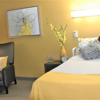 A cozy and bright hospital room featuring yellow accents and comforting decor.