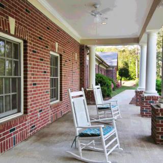A cozy porch with rocking chairs and brick walls, perfect for relaxation.
