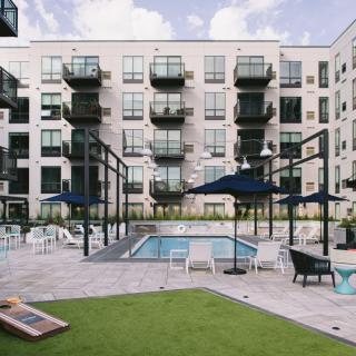 Modern apartment complex with a central pool area and recreational space.