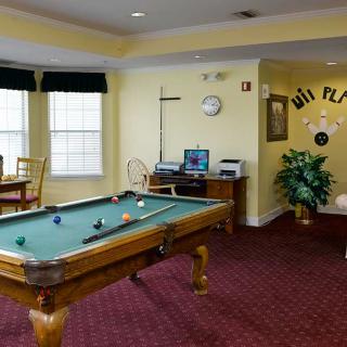 A cozy game room featuring a pool table and comfortable seating.