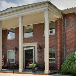 A brick building with large columns at the entrance.