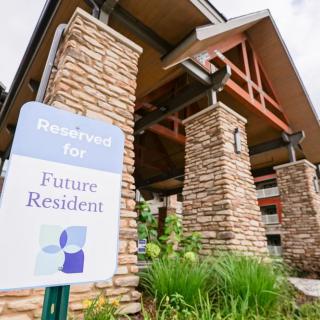 Entrance of a building with a sign indicating reserved parking for future residents.