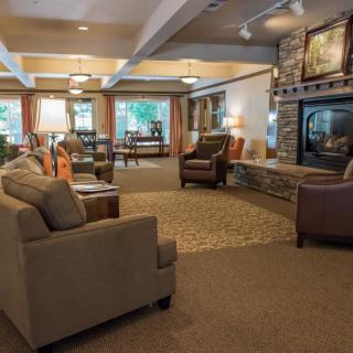 A cozy living room with comfortable seating and a stone fireplace.