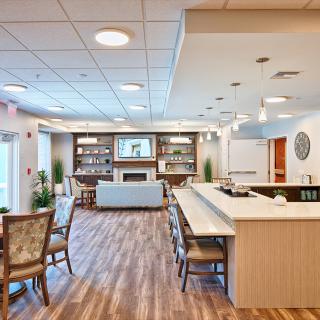 A modern lounge area with comfortable seating, a bar counter, and warm lighting.