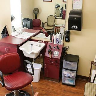 A cozy hair salon interior with a chair, sink, and various styling tools.