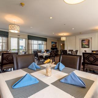 A well-appointed restaurant dining area with neatly arranged tables and blue napkins.