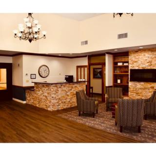 A cozy hotel lobby with a reception desk, comfortable seating, and elegant lighting.