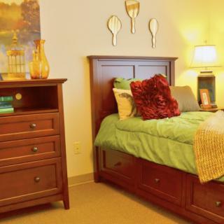 Cozy bedroom setup with wooden furniture and warm lighting.