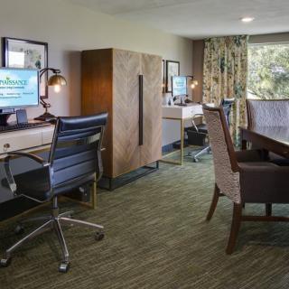 A modern office workspace with desks, computers, and ergonomic chairs.