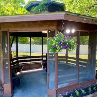 A serene wooden gazebo surrounded by lush greenery, perfect for relaxation.