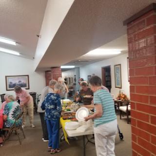 A lively community gathering where people are sharing food and enjoying each other's company.