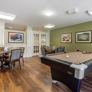 A cozy game room featuring a pool table, seating area, and decorative artwork on the walls.