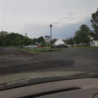 A view of an intersection with a traffic sign under a cloudy sky.