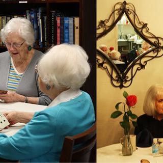 Elderly women enjoying a game of cards and dining together, adorned by a rose and mirror in the background.