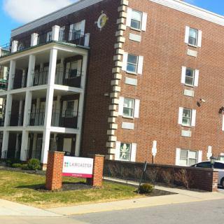 A residential apartment building featuring a brick facade and a welcoming entrance.