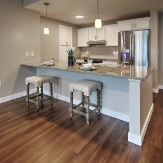 Modern kitchen with granite countertops and bar stools.