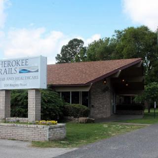 Entrance of a hospitality establishment surrounded by greenery.
