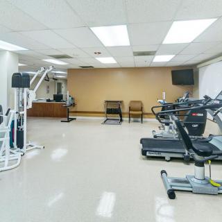 A well-equipped gym with various exercise machines and weights.
