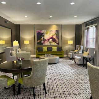 A stylish and modern living room featuring comfortable seating, ambient lighting, and an eye-catching piece of artwork.