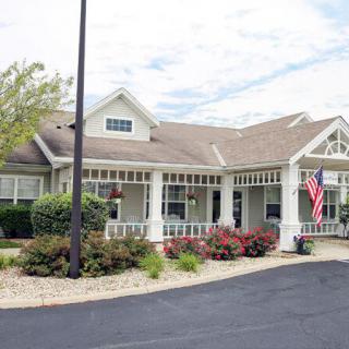 A residential building with an American flag and neatly maintained landscaping.