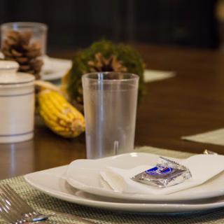 A beautifully arranged dining table featuring elegant dinnerware and seasonal decor.