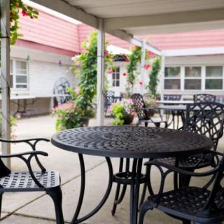 A cozy patio with decorative furniture and lush greenery.