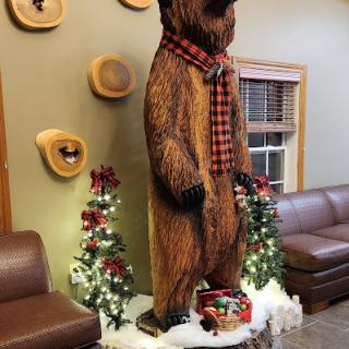 A festive bear sculpture dressed in a plaid scarf, adding charm to the holiday decor.