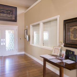 A well-decorated entryway featuring a wooden table with framed photos and artwork on the walls.
