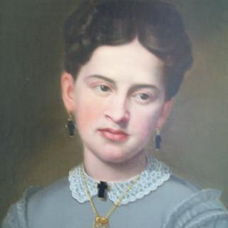 A 19th-century portrait of a woman in classic attire with a lace collar and jewelry.