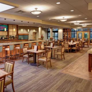 An empty restaurant dining area with neatly arranged tables and chairs.