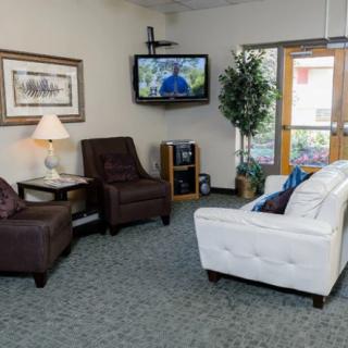 A cozy living room with a sofa, chairs, and a TV.