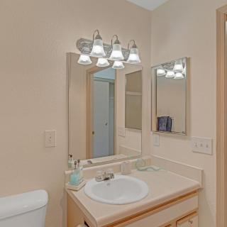 A well-lit bathroom with a sink, mirror, and light fixtures.