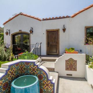 A charming Spanish-style house with a colorful tiled fountain in the courtyard.
