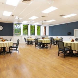 A spacious and well-lit dining room with multiple tables and chairs.