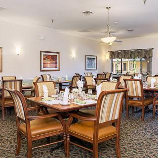 A neatly arranged dining area with several tables and chairs, set for guests.