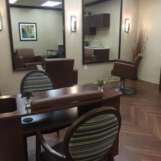 A stylish and modern hair salon featuring comfortable chairs and elegant mirrors.