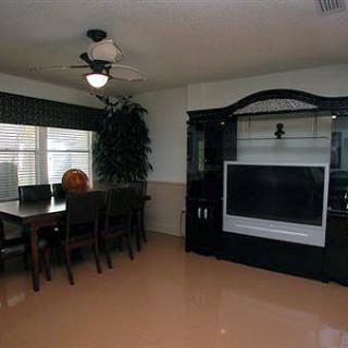 A modern living room with a dining table and a large TV entertainment unit.