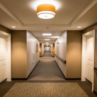 A well-lit hotel hallway with multiple doors on either side.