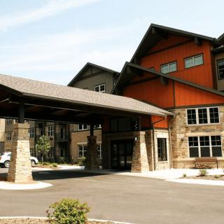 A modern building with a prominent entrance and stone pillars.