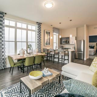 A modern open floor plan living room with a dining area and kitchen, featuring stylish decor and furniture.