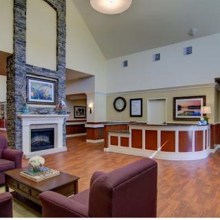 A cozy lobby with a fireplace, reception desk, and comfortable seating.