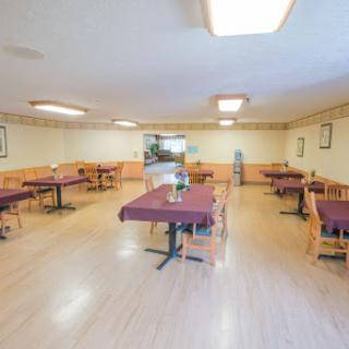 An empty dining area in a casual restaurant, featuring neatly arranged tables and chairs.