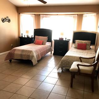 A cozy bedroom with two beds, warm lighting, and tiled flooring.