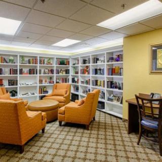 A cozy library reading area with armchairs and bookshelves.