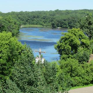 A scenic view of a river surrounded by dense green trees.