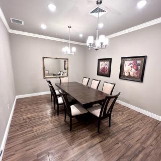 A modern dining room with a sleek table, chairs, and elegant chandelier.