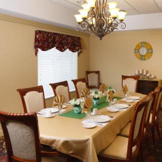 A beautifully arranged dining room featuring an elegant table setting under a decorative chandelier.
