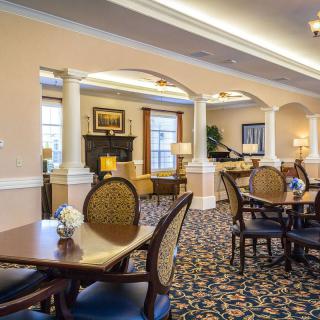 A neatly arranged dining area with elegant furniture and warm lighting.