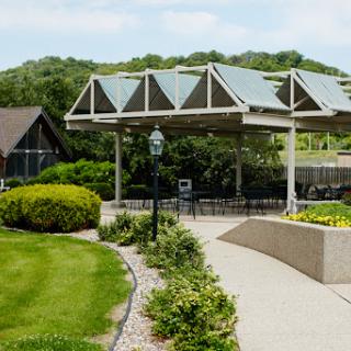 A serene park featuring a landscaped walkway, a pavilion with solar panels, and lush greenery.